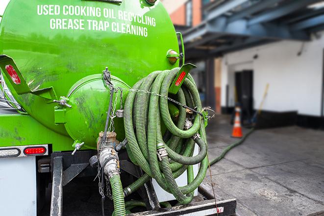 a technician pumping a grease trap in a commercial building in Brandon MS